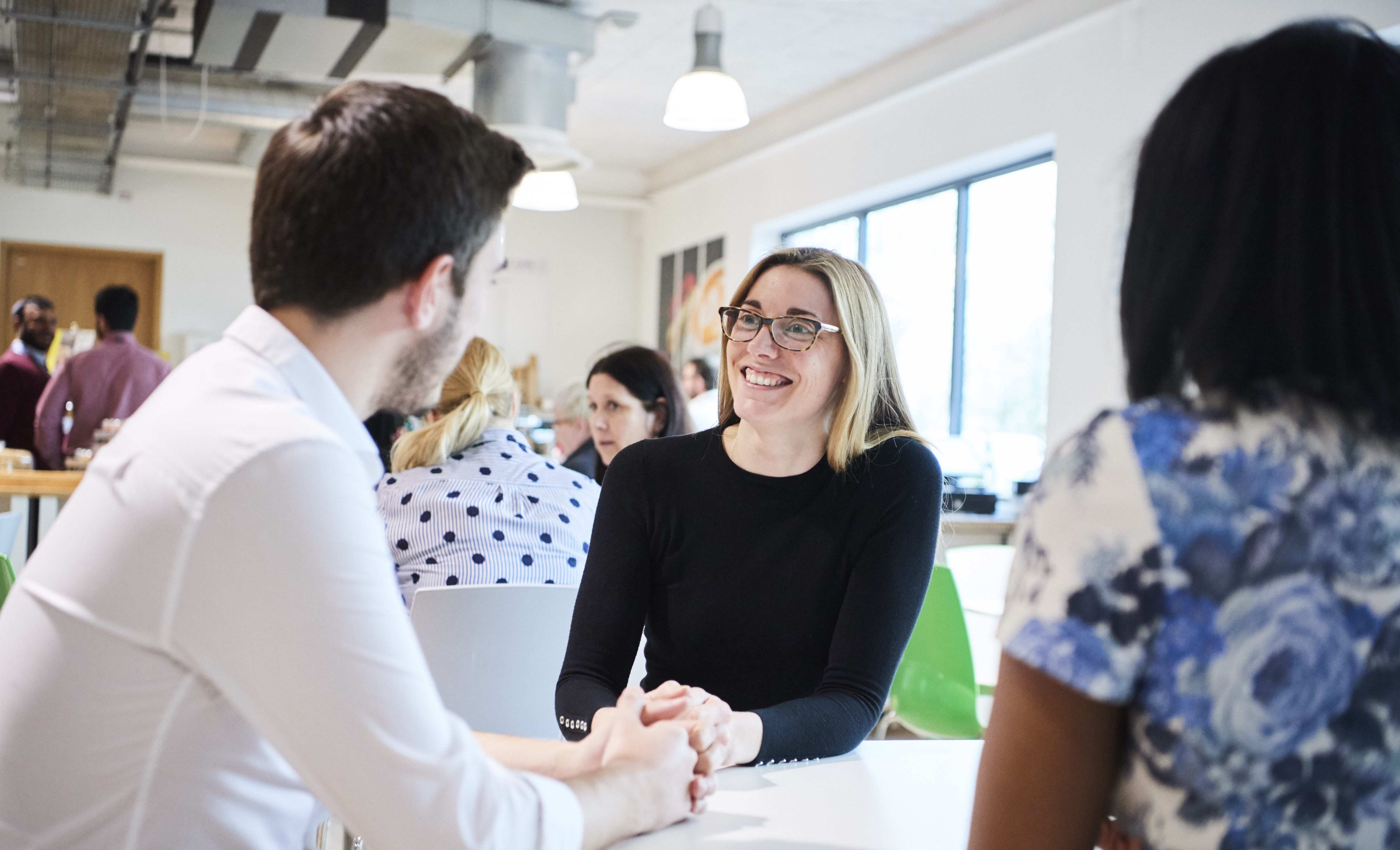 Co-workers sitting in canteen at table having a conversation