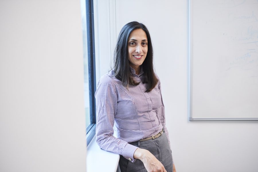 Smiling woman leaning against a windowsill in a conference room