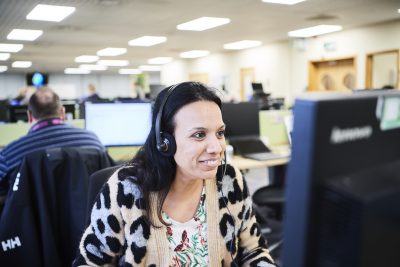 Female sitting at desk wearing head set