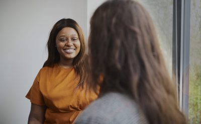 Close up of two female interns having a conversation in an office environment