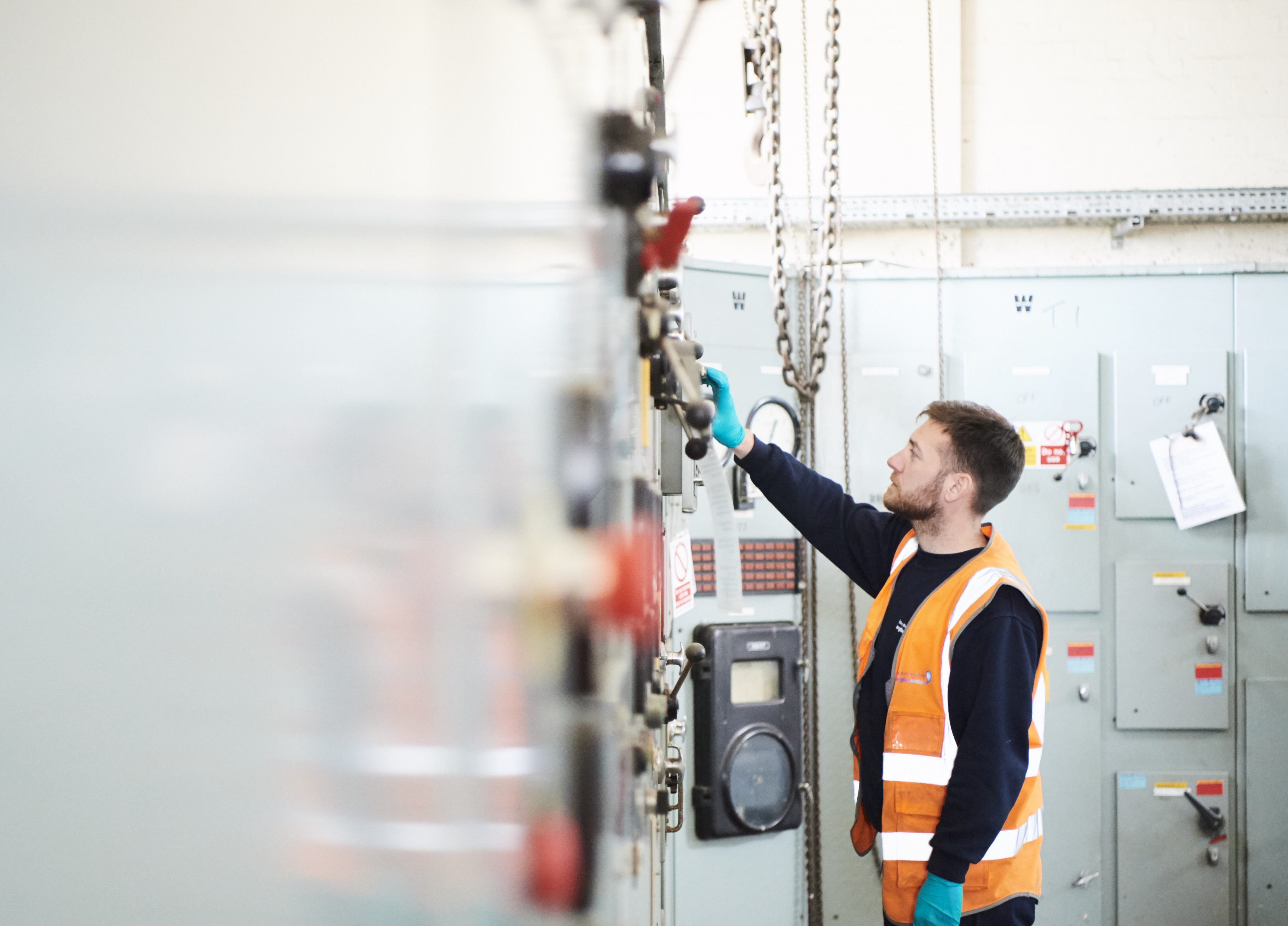 Male in high vis on water treatment plant reaching for a lever